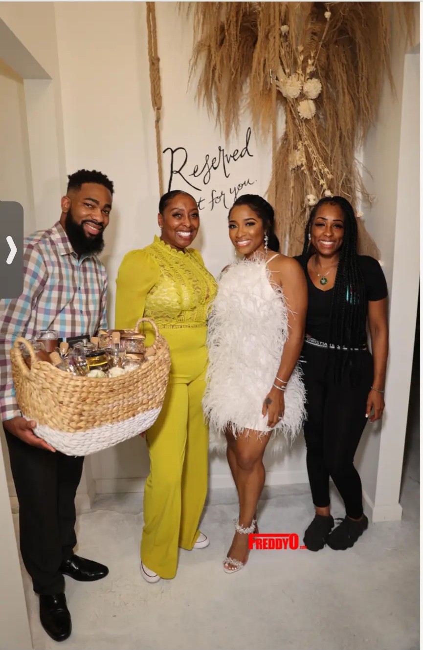 LaTanya Potts with guests and a Hollywood Veganista gift basket at an event